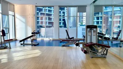 a gym with cardio equipment in a building with windows at BLVD - Stunning Canal View - 5 Minutes from Burj Khalifa in Dubai