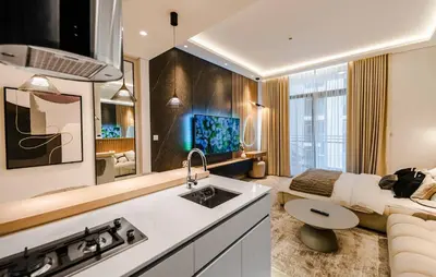a kitchen with a sink and a living room with a bed at Luxury Upgraded Studio in Wilton Park Residences in Dubai