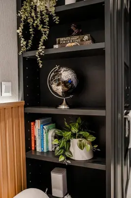 a book shelf with a plant and a globe on it at Luxury Upgraded Studio in Wilton Park Residences in Dubai