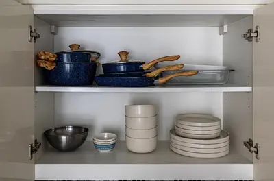 a cupboard with dishes and bowls on a shelf at Luxury Penthouse - Scenic View - Near Burj Khalifa in Dubai