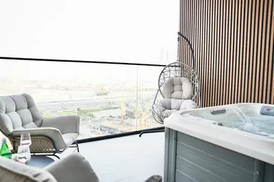 a room with chairs and a tub on a balcony at Private jacuzzi Canal View Infinity Pool in Dubai