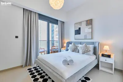 a bedroom with a large bed and a large window at bnbmehomes - Act One Tower in Dubai