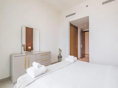 a white bedroom with a large white bed and a mirror at TRPS - BLVD Heights, Downtown Dubai - Luxury 1BR, Close to Dubai Mall in Dubai
