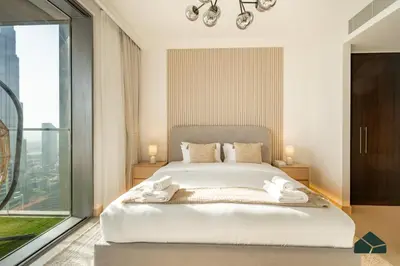 a bedroom with a large bed and a large window at High Floor 2BR with Full Burj View by BMS in Dubai
