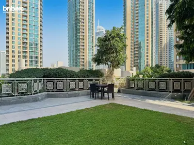 a table and bench in a park with tall buildings at bnbmehomes - 29 Boulevard Tower 1 in Dubai