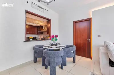 a dining room with chairs and a table with flowers on it at bnbmehomes - 29 Boulevard Tower 1 in Dubai