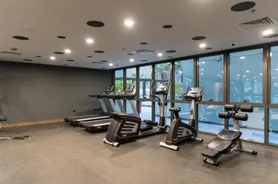a gym with a row of treadms and elliptical machines at Lux & New 2 BHK in Jumeirah Village Circle I Close to everything I Pool I High Speed Internet I Balcony in Dubai