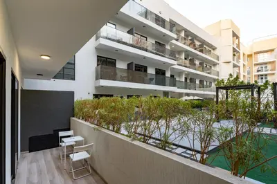an apartment building with a balcony and a swimming pool at Lux & New 2 BHK in Jumeirah Village Circle I Close to everything I Pool I High Speed Internet I Balcony in Dubai