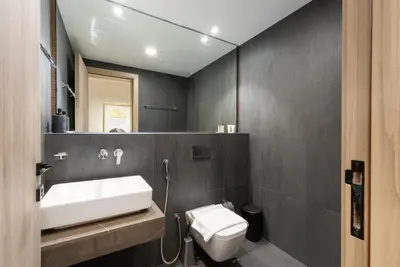 a bathroom with a sink and a toilet and a mirror at Lux & New 2 BHK in Jumeirah Village Circle I Close to everything I Pool I High Speed Internet I Balcony in Dubai