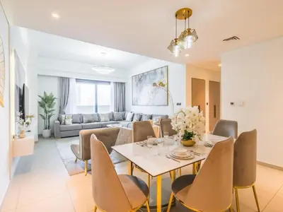 a dining room and living room with a table and chairs at TRPS - Act One Act Two Towers, Downtown Dubai - 3BR Plus Maid with Iconic Burj Khalifa View in Dubai