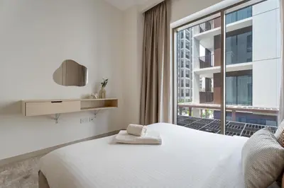 a bedroom with a bed and a large window at GuestReady - Tasteful home in Dubai Creek Harbour in Dubai