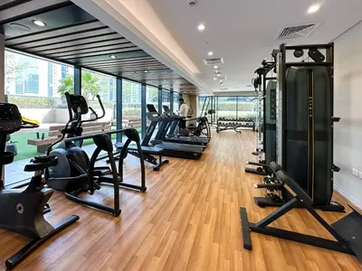 a gym with treadmills and elliptical machines at Chic 1BR in Business Bay City Views & Upscale Comfort in Dubai