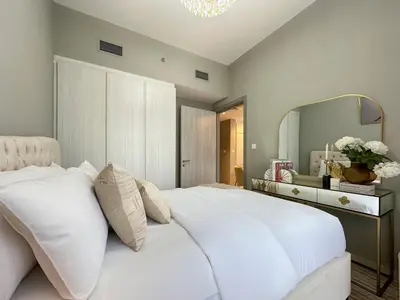 a bedroom with a large white bed and a mirror at Chic 1BR in Business Bay City Views & Upscale Comfort in Dubai