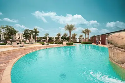 a swimming pool with blue water in a resort at Elegant 4BR Villa, Luxury Pool Retreat, Joy, Arabiana Ranches 3 in Sabkhah