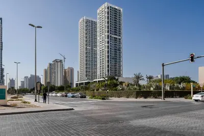 an empty street in a city with tall buildings at Soft Modernity 1br Haven With Parking, Gym & Pool! in Dubai