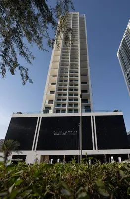 a tall building with black solar panels on it at Soft Modernity 1br Haven With Parking, Gym & Pool! in Dubai