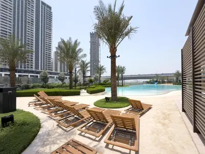 a row of chaise lounge chairs and a pool at GuestReady - Stylish Stay with Dubai Skyline Views in Dubai