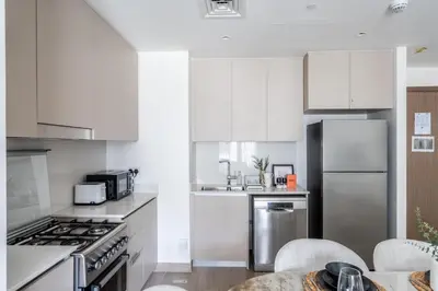 a kitchen with white cabinets and stainless steel appliances at GuestReady - Stylish Stay with Dubai Skyline Views in Dubai