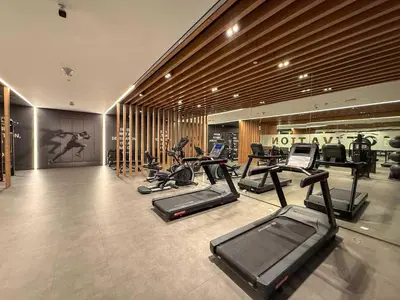a gym with a row of treadmills and exercise bikes at Frank Porter - Taraf 2 Residence in Dubai