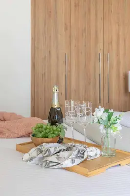 a table with wine glasses and a bowl of green grapes at Frank Porter - Taraf 2 Residence in Dubai