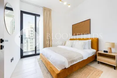 a bedroom with a bed and a large window at Bloomfields Cozy 1BR Binghatti Nova in Dubai