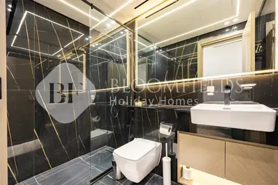 a bathroom with a white toilet and a sink at Bloomfields Cozy 1BR Binghatti Nova in Dubai