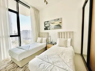 two beds in a hotel room with a window at Elevated 2br Elegance Dip Pool, Parking And Gym! in Dubai