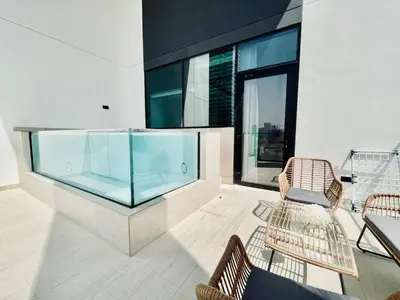 a room with a glass aquarium and two chairs at Elevated 2br Elegance Dip Pool, Parking And Gym! in Dubai
