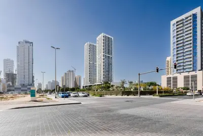 an empty street in a city with tall buildings at Elevated 2br Elegance Dip Pool, Parking And Gym! in Dubai