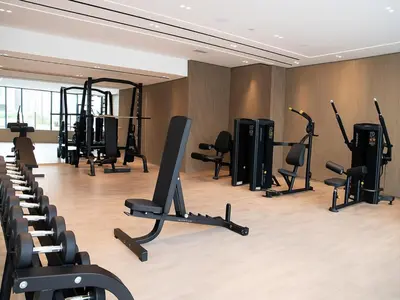a gym with several treadmills and exercise bikes at Big 1BR Apartment in JVC Binghatti Corners in Dubai