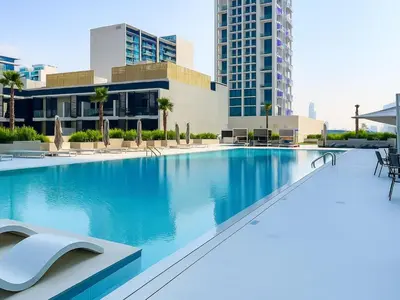a large swimming pool in the middle of a building at Big 1BR Apartment in JVC Binghatti Corners in Dubai
