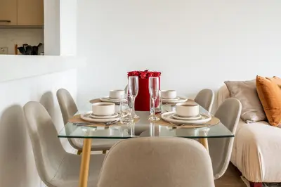 a dining room with a glass table and chairs at New! 1BR with Balcony Views and Pool by Burj Khalifa in Dubai