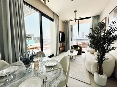 a living room with a table and chairs and a large window at Sun Deck & Sleek Lap Pool Free Gym And Parking! in Dubai