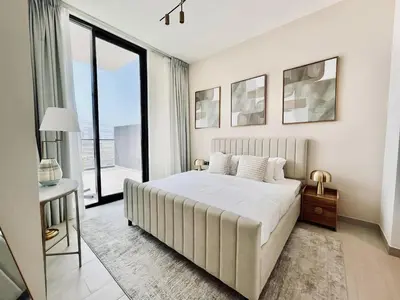 a white bedroom with a large bed and a window at Sun Deck & Sleek Lap Pool Free Gym And Parking! in Dubai