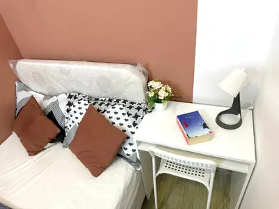 a bed with pillows and a nightstand with a table at Duo Den Partiton Room In tecom Barsha Heights in Dubai