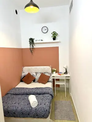 a small bedroom with a bed and a table at Duo Den Partiton Room In tecom Barsha Heights in Dubai
