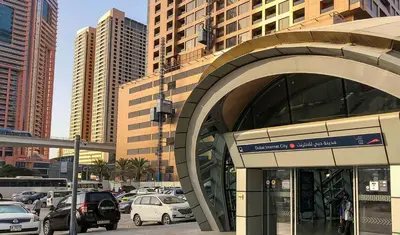 a building with cars parked in a parking lot at Enchanted Stay Partition Room in Barsha Heights in Tecom in Dubai