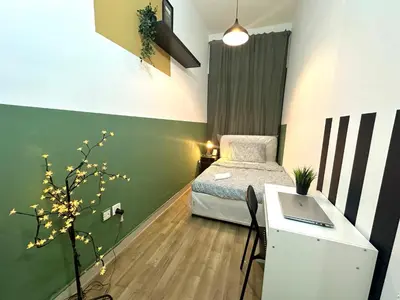 a room with a bed and a desk with a laptop at Passion Nest Room in Barsha Heights Tecom in Dubai