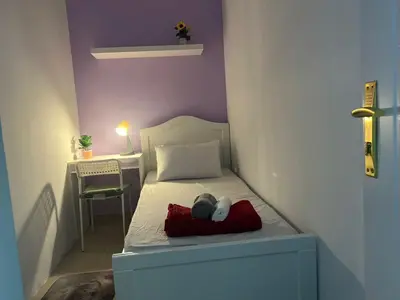 a small bedroom with a bed and a table at Solo Haven Room in Barsha Heights Tecom in Dubai