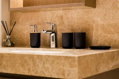 a bathroom sink with a faucet and two cups at Luxury Oasis | Private Beach & Infinity Pool in Dubai