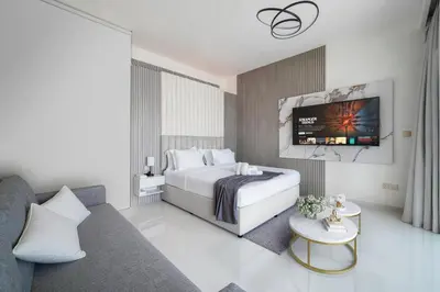 a hotel room with a bed and a tv at Luxury Oasis | Private Beach & Infinity Pool in Dubai