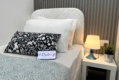a white bed with a pillow and a sign on it at Best Solo Room in Barsha heights Tecom in Dubai