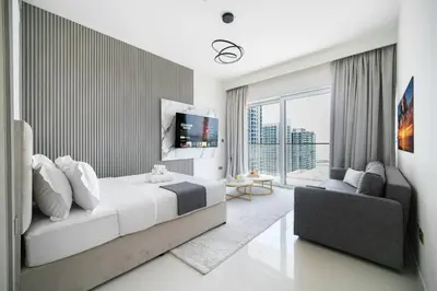 a bedroom with a bed and a tv and a couch at Ultra Luxury Apt | Private Beach + Infinity Pool in Dubai