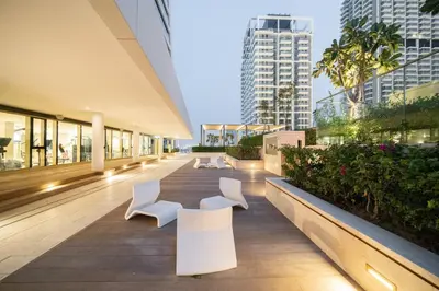 a building with white chairs and buildings at Ultra Luxury Apt | Private Beach + Infinity Pool in Dubai