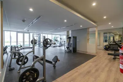 a gym with treadmills and machines in a room at Comfy 1BR with Large Balcony - 15-min to Mall & Burj in Dubai