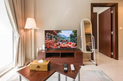a living room with a flat screen tv on a wall at Comfy 1BR with Large Balcony - 15-min to Mall & Burj in Dubai