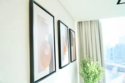 a row of framed pictures on a wall next to a window at Spacious 1BR Balcony Jacuzzi in Dubai