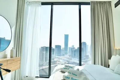 a bedroom with a bed and a large window at Spacious 1BR Balcony Jacuzzi in Dubai