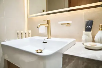 a white sink with a gold faucet in a bathroom at Jacuzzi Canal view BusinessBay in Dubai