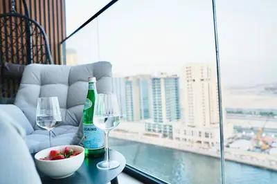 a table with two wine glasses and a bowl of fruit at Jacuzzi Canal view BusinessBay in Dubai